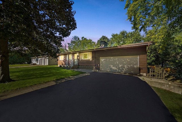 ranch-style home with a lawn and a garage