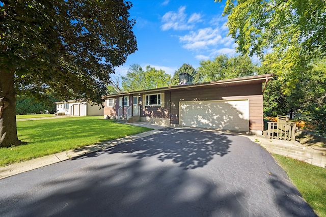 ranch-style house featuring a garage and a front lawn