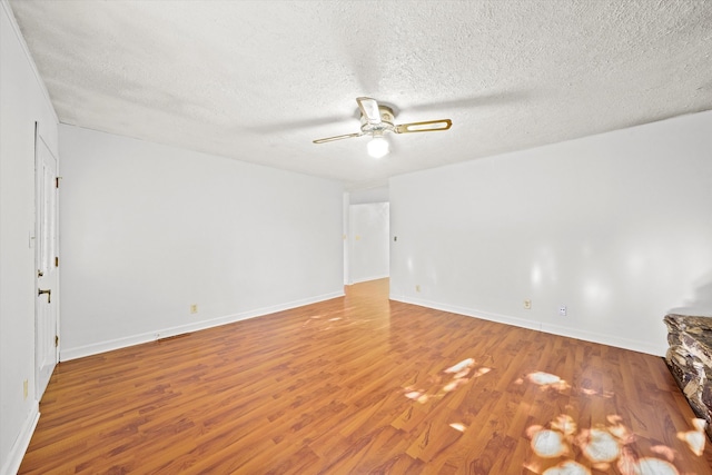 empty room featuring a textured ceiling, ceiling fan, and wood-type flooring