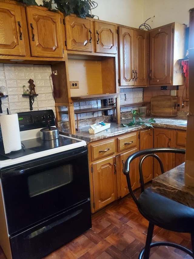 kitchen with dark parquet flooring, black range with electric stovetop, and backsplash