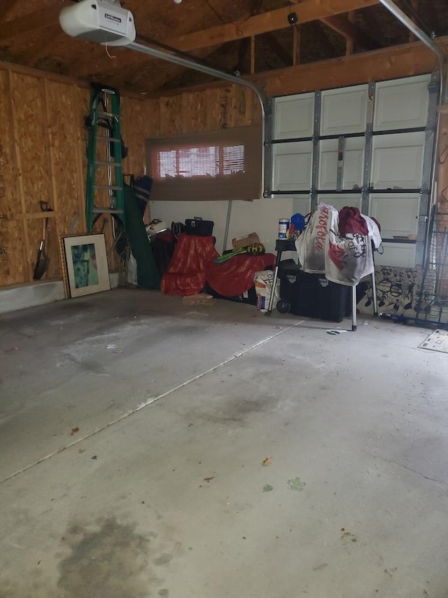 garage with wood walls and a garage door opener