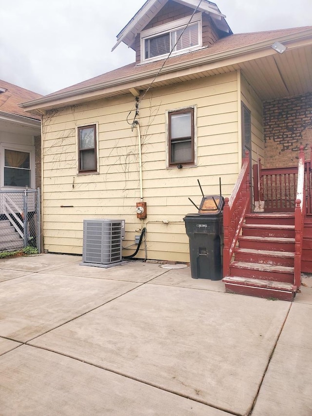 view of side of home with central AC and a patio area