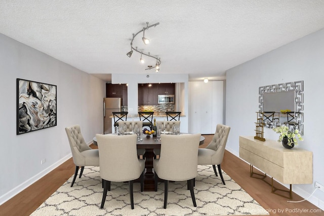 dining space featuring a textured ceiling and light wood-type flooring