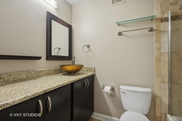 bathroom with vanity, toilet, and tiled shower