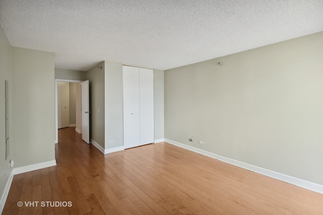 spare room with a textured ceiling and hardwood / wood-style floors