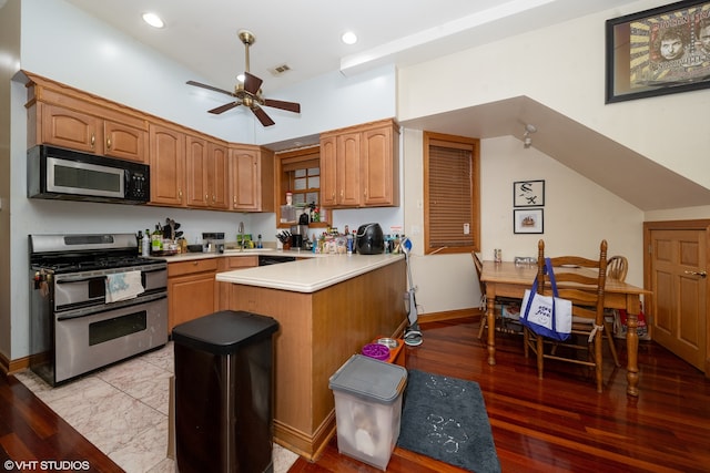 kitchen featuring gas range, light hardwood / wood-style flooring, kitchen peninsula, and ceiling fan