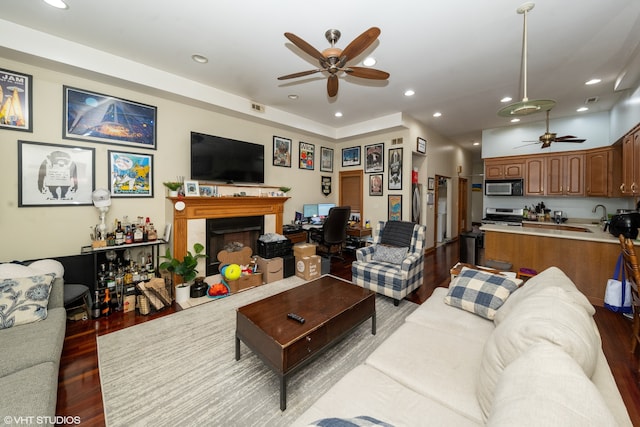 living room featuring hardwood / wood-style flooring, sink, and ceiling fan