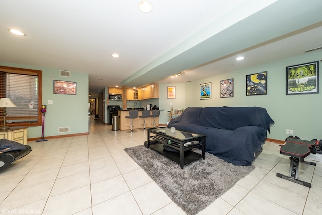 living room with indoor bar and light tile patterned flooring