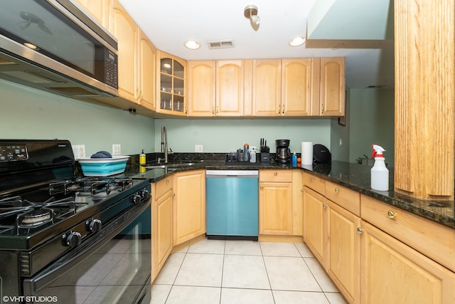 kitchen with appliances with stainless steel finishes, light tile patterned floors, sink, and light brown cabinets