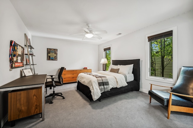 carpeted bedroom with multiple windows and ceiling fan