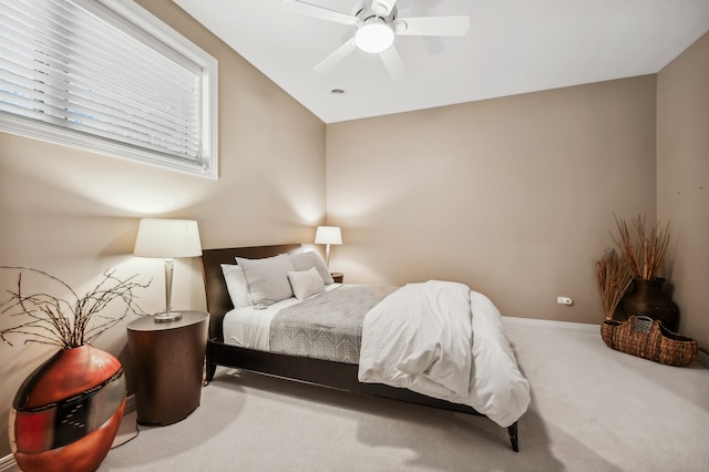 bedroom with ceiling fan, lofted ceiling, and carpet flooring