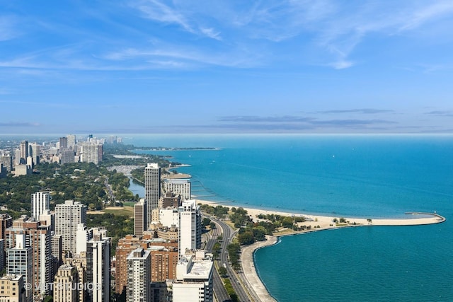 drone / aerial view featuring a water view, a view of the beach, and a city view