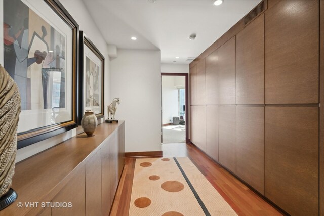 hallway with light hardwood / wood-style floors and a wealth of natural light