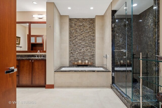 bathroom featuring vanity, plus walk in shower, and tile walls