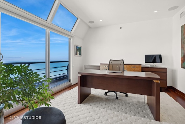 office space featuring a water view, wood finished floors, and recessed lighting