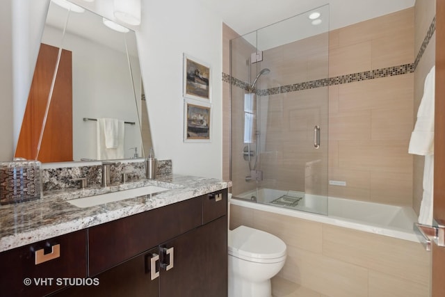 bathroom with tiled shower / bath combo, toilet, and vanity