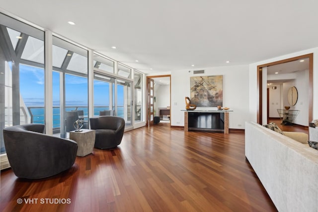 living area featuring recessed lighting, visible vents, expansive windows, wood finished floors, and baseboards