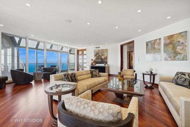 living area with a wall of windows, recessed lighting, and wood finished floors