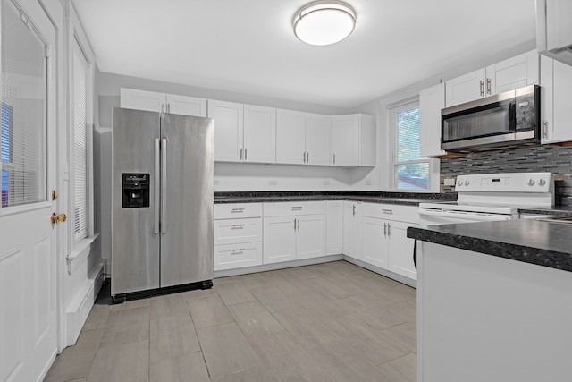 kitchen with tasteful backsplash, stainless steel appliances, and white cabinetry