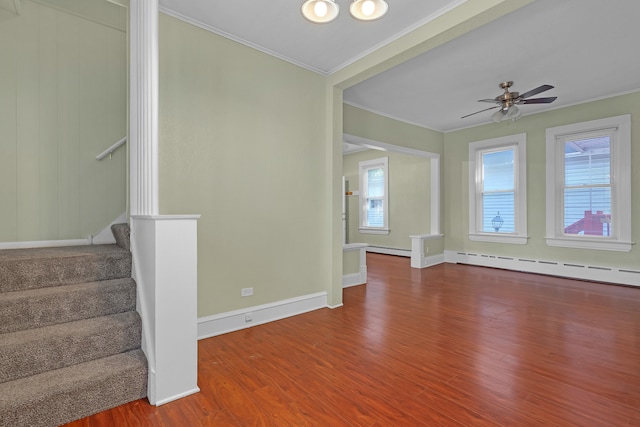 unfurnished living room featuring hardwood / wood-style floors, ceiling fan, a baseboard heating unit, and ornamental molding