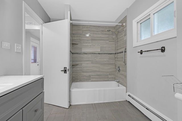 bathroom with tile patterned flooring, vanity, baseboard heating, and tiled shower / bath combo