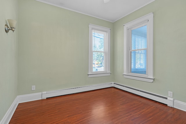 spare room with a baseboard heating unit, ornamental molding, and dark hardwood / wood-style floors