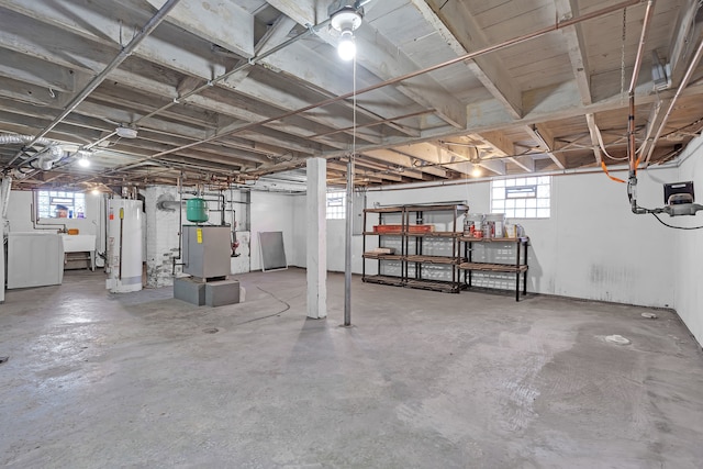 basement featuring gas water heater, a wealth of natural light, and separate washer and dryer