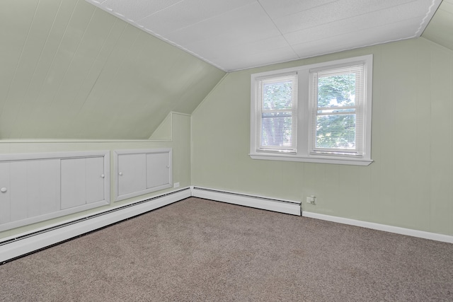 additional living space featuring vaulted ceiling, a baseboard radiator, and carpet floors