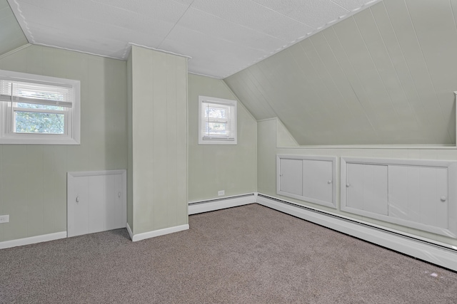 bonus room with a baseboard heating unit, vaulted ceiling, light carpet, and a wealth of natural light