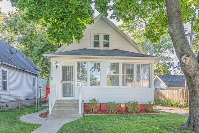 bungalow-style home with a front yard