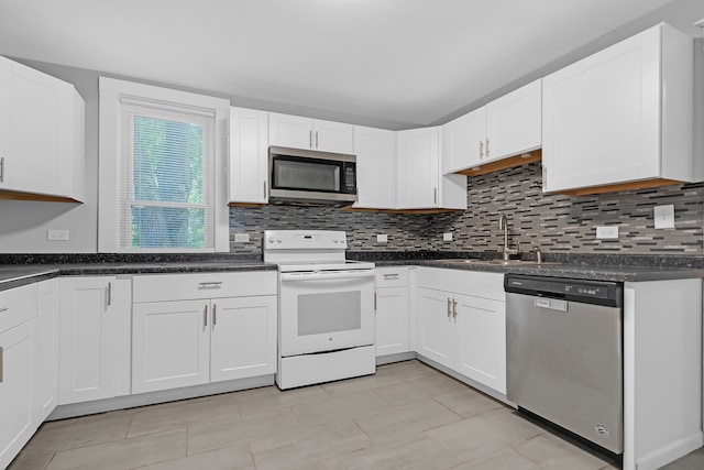 kitchen with white cabinets, stainless steel appliances, decorative backsplash, and sink