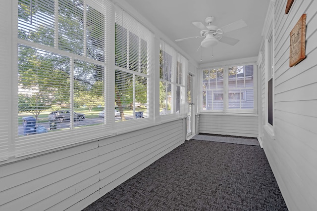 unfurnished sunroom with ceiling fan