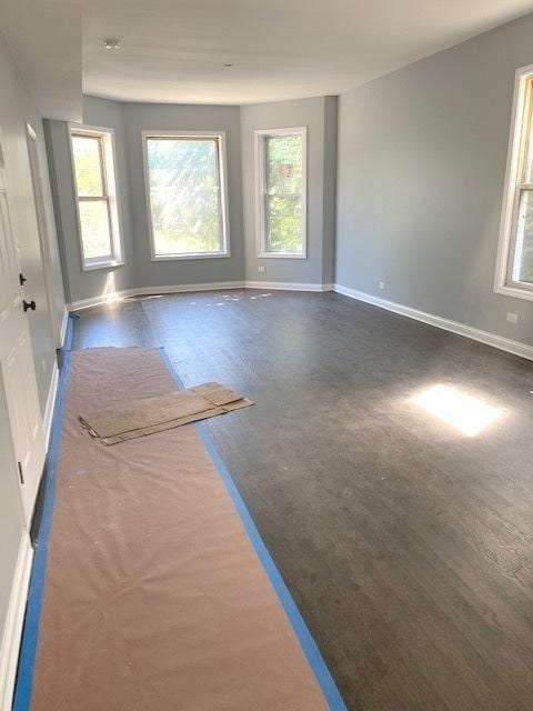 unfurnished room featuring baseboards and wood finished floors