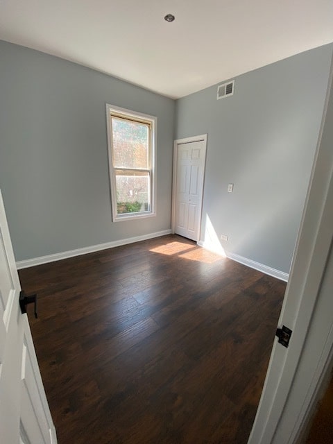 spare room with dark wood-type flooring