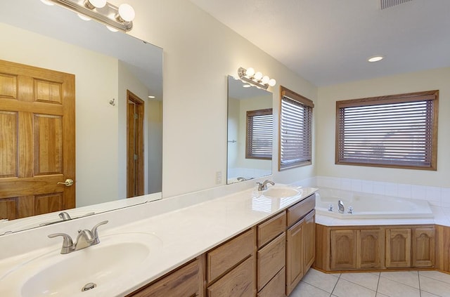 bathroom with tile patterned floors, a bath, double vanity, and a sink