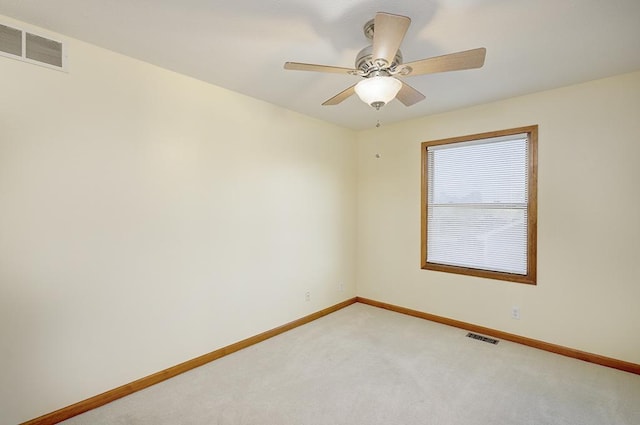 spare room featuring baseboards, visible vents, and light carpet