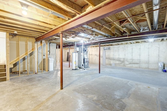 unfinished below grade area with gas water heater, heating unit, and washer / clothes dryer