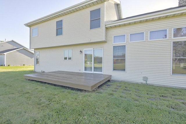 rear view of house featuring a lawn and a deck