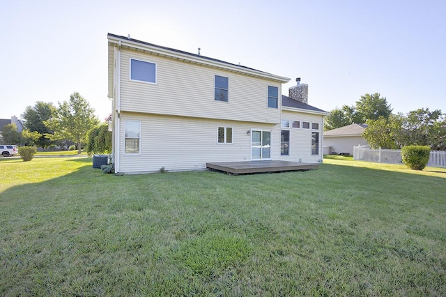 back of property featuring central air condition unit, a yard, a wooden deck, and a chimney