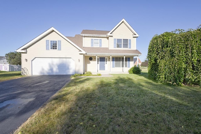 traditional-style house with a front yard, a garage, and driveway