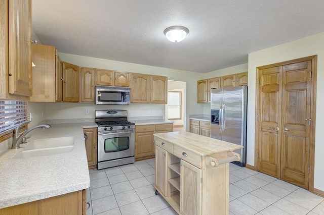 kitchen featuring a sink, stainless steel appliances, light tile patterned flooring, and butcher block counters