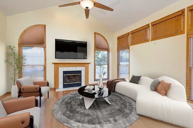 living area featuring lofted ceiling, light wood-style floors, ceiling fan, and a fireplace