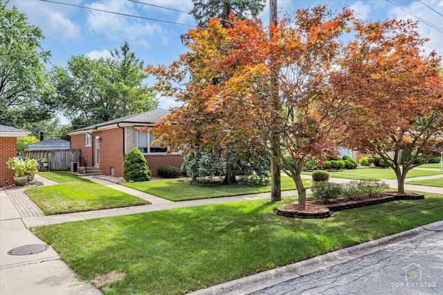 view of property hidden behind natural elements featuring entry steps, brick siding, and a front lawn