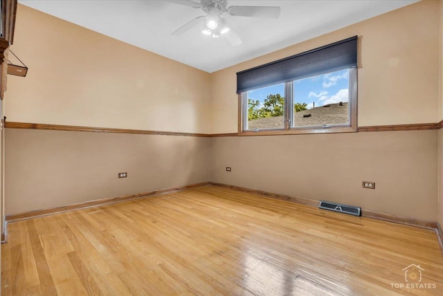 unfurnished room with light wood finished floors, a ceiling fan, visible vents, and baseboards