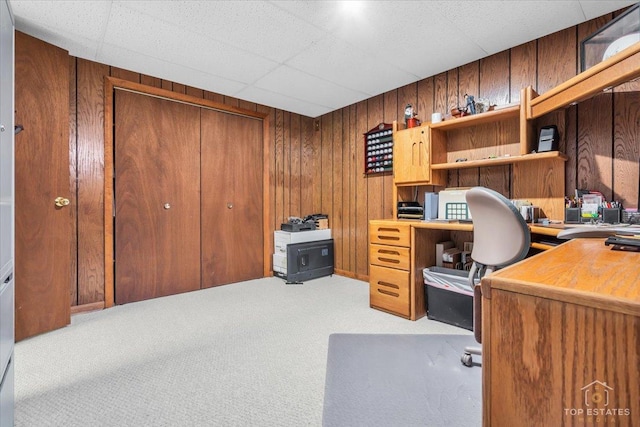 home office with carpet floors and wooden walls