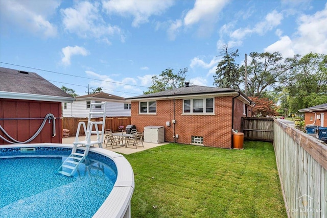 rear view of property with a patio area, brick siding, a yard, and a fenced backyard