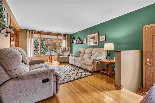 living room with crown molding and wood finished floors