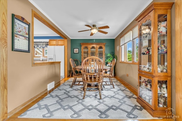 dining room featuring ceiling fan, light hardwood / wood-style floors, and crown molding