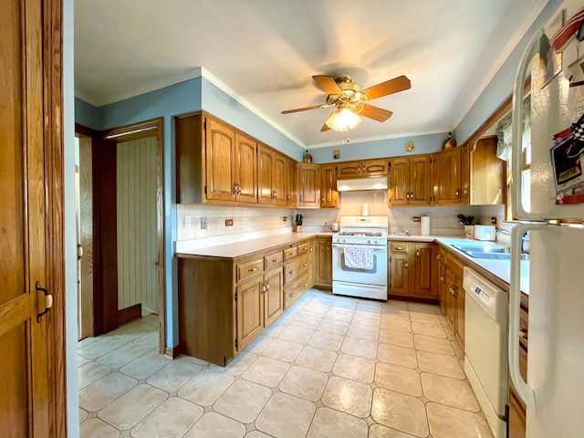 kitchen with ceiling fan, backsplash, ornamental molding, sink, and white appliances