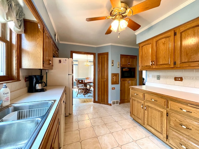 kitchen featuring sink, crown molding, backsplash, and ceiling fan